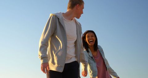 Laughing Friends Walking Outdoors on Sunny Day