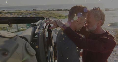 Couple embracing in scenic view near ocean with off road vehicle