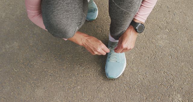 Athletic Person Tying Running Shoes on Outdoor Pavement - Download Free Stock Images Pikwizard.com