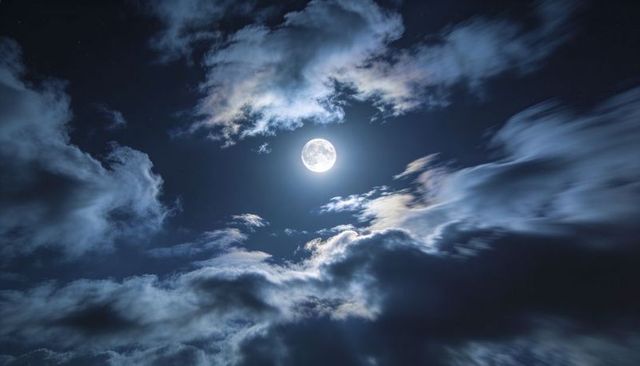 Full Moon Halo over Dramatic Night Sky with Layered Clouds