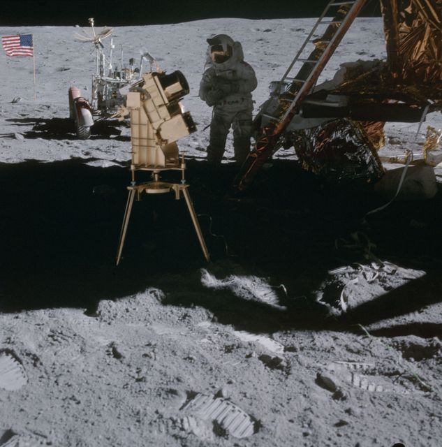 Astronaut Charles M. Duke Jr., lunar module pilot, sets up an ultraviolet camera beside the Apollo 16 Lunar Module during the second EVA of the mission. The scene, captured by astronaut John W. Young, commander, includes a clear shot of the Lunar Roving Vehicle and the American flag in the background. Ideal for educational content, historical documentaries, science visuals, and NASA-related articles.