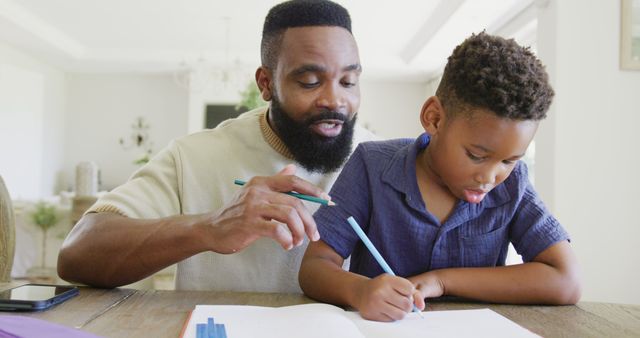 Father Helping Young Son with Homework in Dining Room - Download Free Stock Images Pikwizard.com