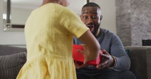Daughter Giving Gift to Surprised Father Celebrating Family Bond