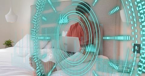 Working remotely on bed using laptop while cyan AR HUD overlay visualizes data