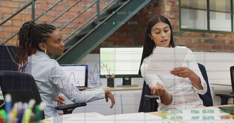 Business colleagues analyzing financial documents in industrial office