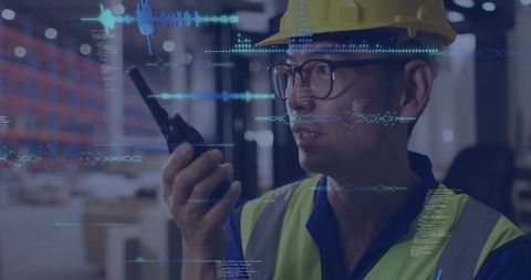 Industrial worker using walkie-talkie with technology overlays in warehouse