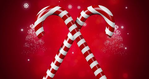 Crossed candy canes with sparkling stars on red background