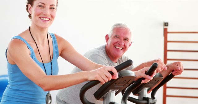 Smiling Older and Younger Adults Exercising on Stationary Bikes at Gym - Download Free Stock Images Pikwizard.com