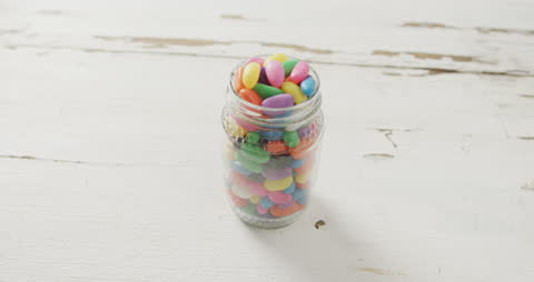 Jar of Multicolored Jelly Sweets on Rustic White Surface