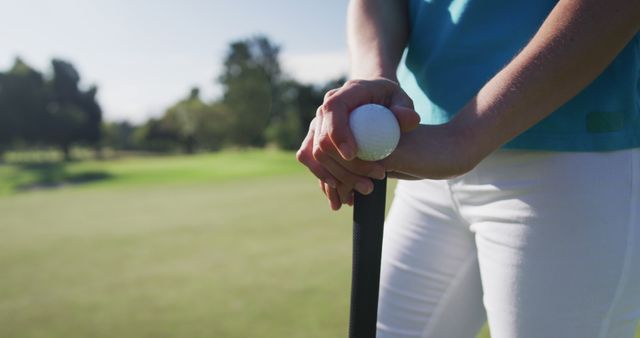 Caucasian female golf player holding a ball and a golf club standing on golf field. golf sports hobby healthy lifestyle.