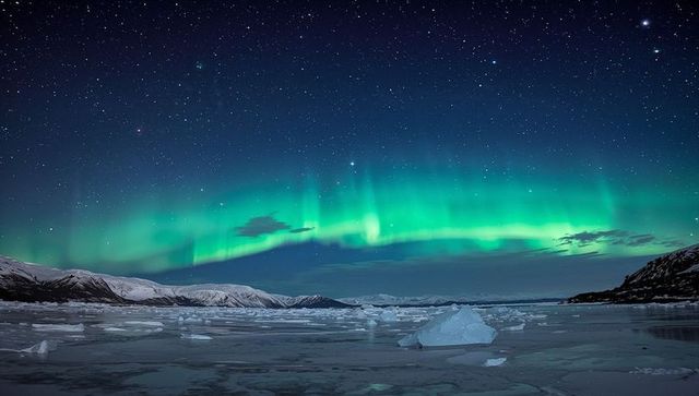 Green aurora arching over icy arctic fjord under starry night sky