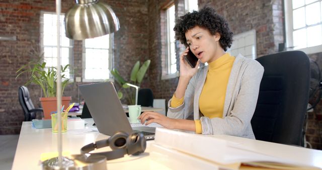 Focused professional woman talking on phone at modern office workspace - Download Free Stock Images Pikwizard.com