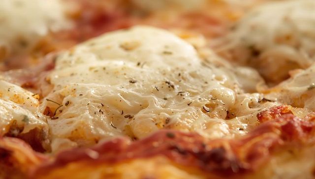 Melting mozzarella pizza topped with soft baked egg, roasted tomato and herbs