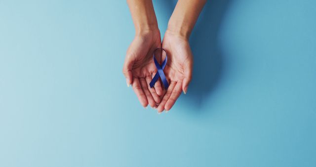 Female Hands Holding Blue Awareness Ribbon on Light Blue Background - Download Free Stock Images Pikwizard.com