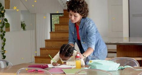 Caregiver guiding child doing homework at kitchen table with backpack and notebooks