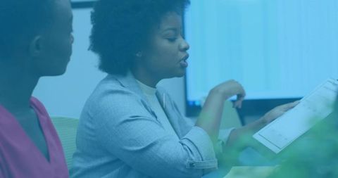 Two Professionals Analyzing Charts in Corporate Setting