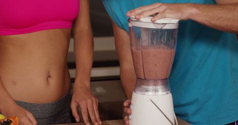 People Blending Fresh Smoothie in Modern Kitchen