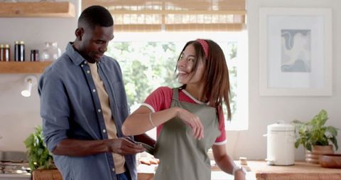 Couple Cooking Together in Cozy Modern Kitchen with Smartphone