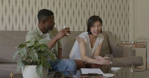 Couple happily planning wedding on comfortable living room sofa