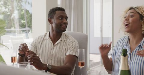 Friends Laughing Together While Enjoying a Celebration at Home