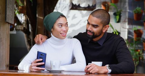 Couple in Cafe Enjoying Time Together with Smartphone
