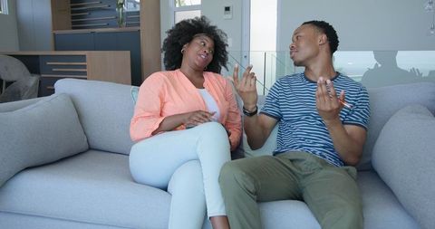 Couple Engaging in Relaxed Conversation on Modern Sofa
