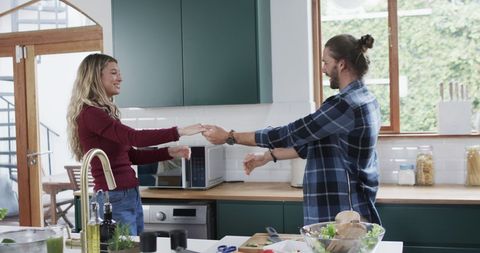 Diverse Couple Dancing Happily in Kitchen at Home