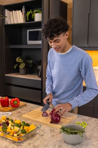 Man slicing red onion in modern kitchen enhances gourmet cooking