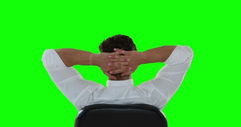 Businessman Relaxing in Chair with Green Screen Backdrop