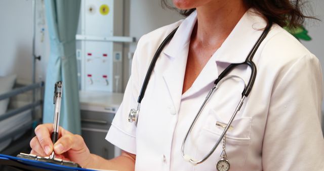 Female doctor writing on clipboard in hospital room - Download Free Stock Images Pikwizard.com