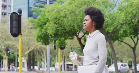 Young Business Woman Holding Laptop and Checking Time in City