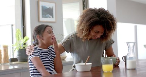 Happy Mother and Daughter Enjoying Breakfast at Home
