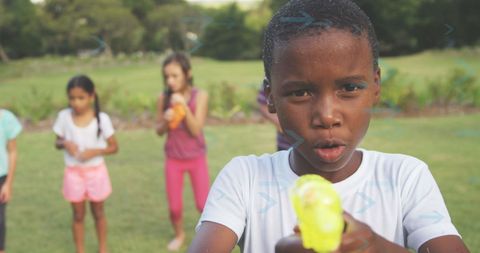 Children playing with water guns in garden party fun
