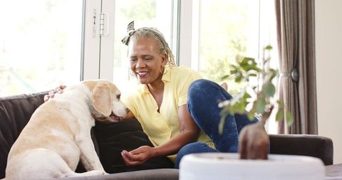 African american senior woman bonding with pet dog