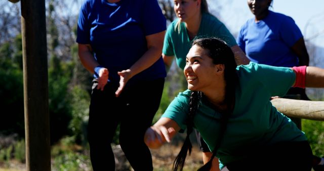 Women competing in an outdoor obstacle course, highlighting teamwork and athleticism. Suitable for use in promotional materials for fitness events, team-building activities, or sports competitions. Can also be used to emphasize themes of empathy, diversity, and friendship in advertisements and social media posts.