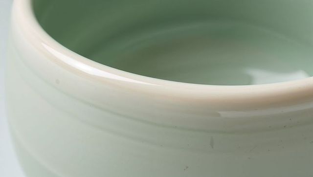 Pale celadon jar showcasing glossy beige rim and subtle wheel-thrown texture