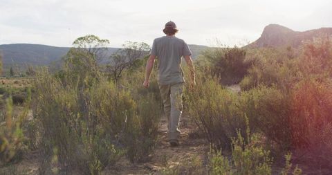 Man Trekking on Trail Through Remote Rocky Scrubland
