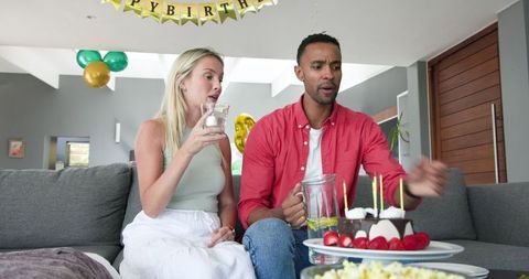 Couple Celebrating Birthday at Home with Cake and Candles