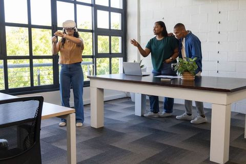 African american team testing vr headset in bright minimalist office workspace