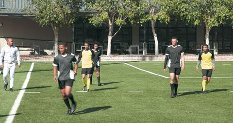 Youth soccer players celebrating victory on school field
