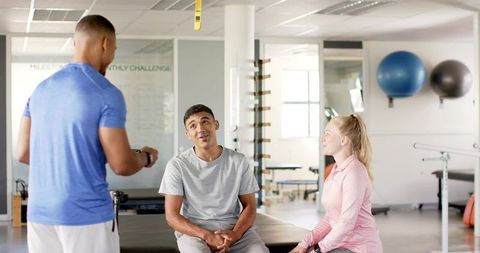 Therapist Coaching Male and Female Clients During Rehab Session in Bright Clinic