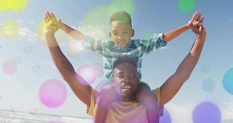 Father and Son Enjoying Fun Beach Playtime with Colorful Lights