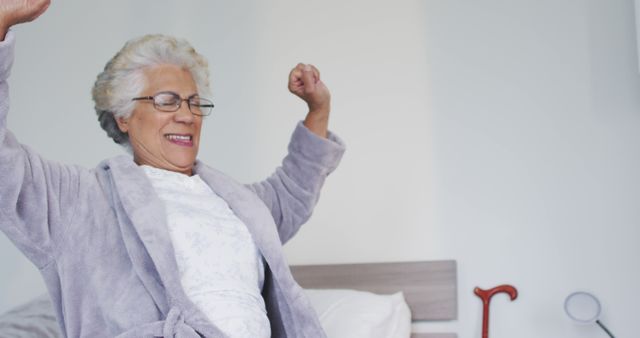 Senior Relative Stretching in Bed wearing Bathrobe - Download Free Stock Images Pikwizard.com