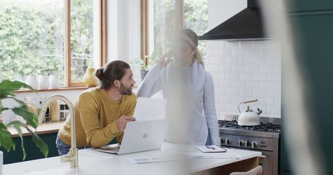 Diverse Couple Working From Home in Bright Kitchen