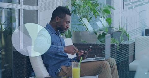 Young Professional Multitasking with Smartphone and Laptop