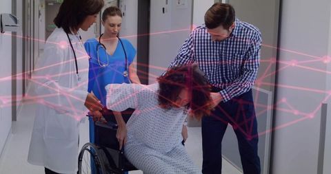 Pregnant patient lowering into wheelchair with medical team assisting and pink health overlay