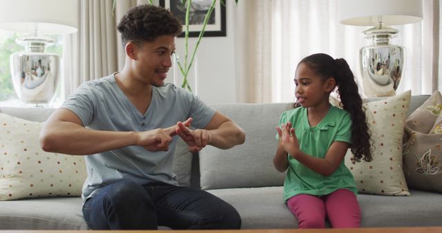 Father Sitting With Daughter Learning Sign Language in Living Room - Download Free Stock Images Pikwizard.com