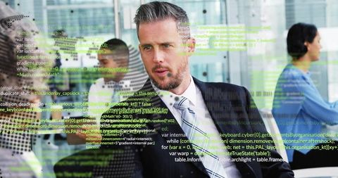 Corporate executive studying code overlay on glass partition during office collaboration