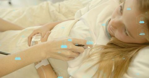 Nurse listening to young girl heartbeat with stethoscope on hospital bed, pediatric care