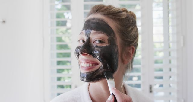Smiling Woman Applying Beauty Face Mask at Home - Download Free Stock Images Pikwizard.com
